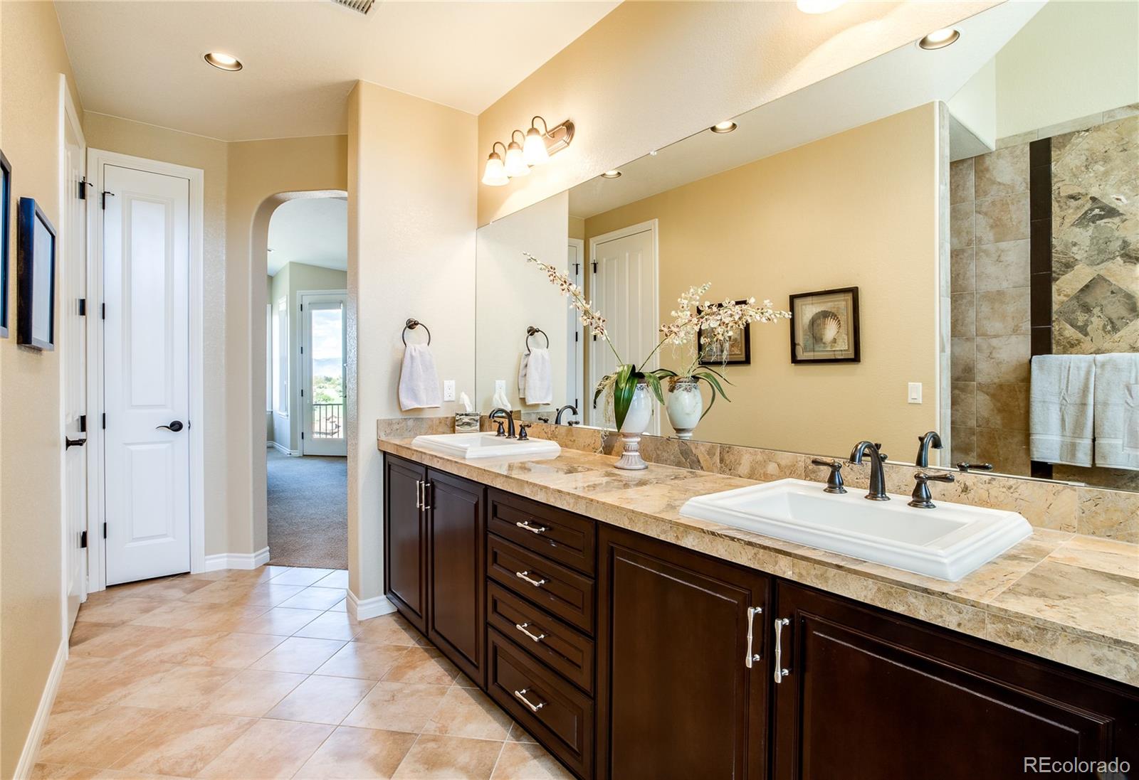9349 Viaggio Way Highlands Ranch, CO 80126 - Photo 23 of 35 a bathroom with a granite countertop double vanity sink shower and a mirror