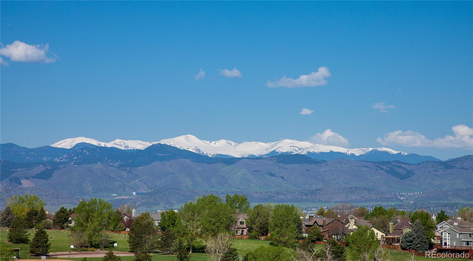 9349 Viaggio Way Highlands Ranch, CO 80126 - Photo 33 of 35 a view of a lush green hillside and a building in the background