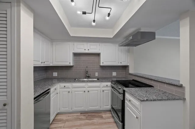 a kitchen with a sink stove and cabinets