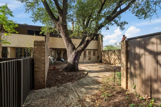 a view of a house with a tree in the backyard