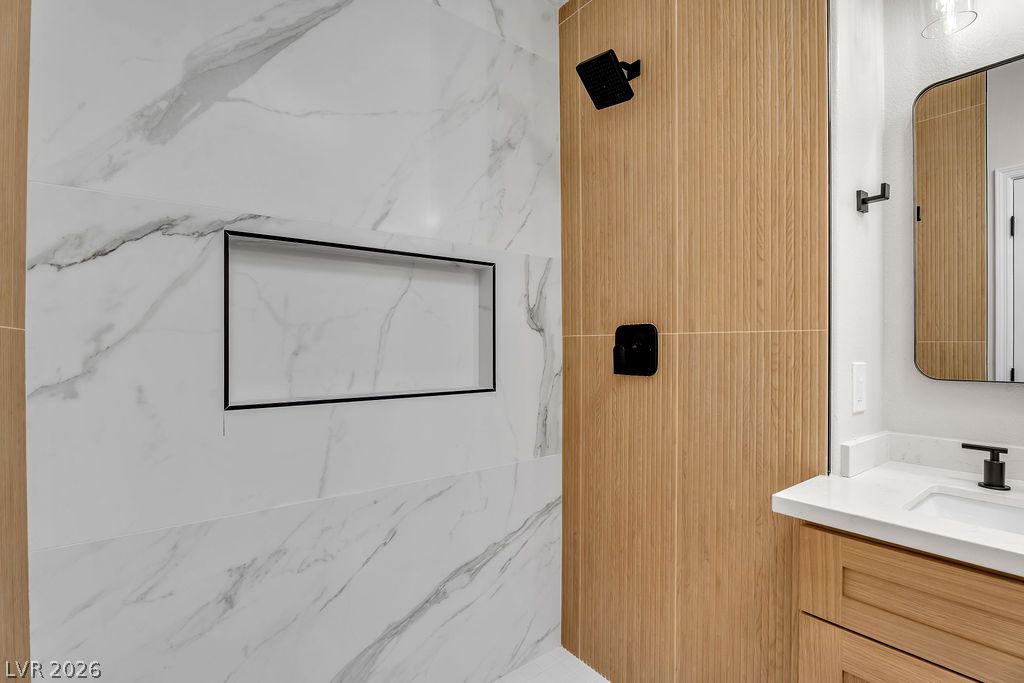 2139 Chapman Ranch Drive Henderson, NV 89012 - Photo 46 of 58 Marble-clad walls and sleek wooden accents define this modern shower space, offering a refined aesthetic.
