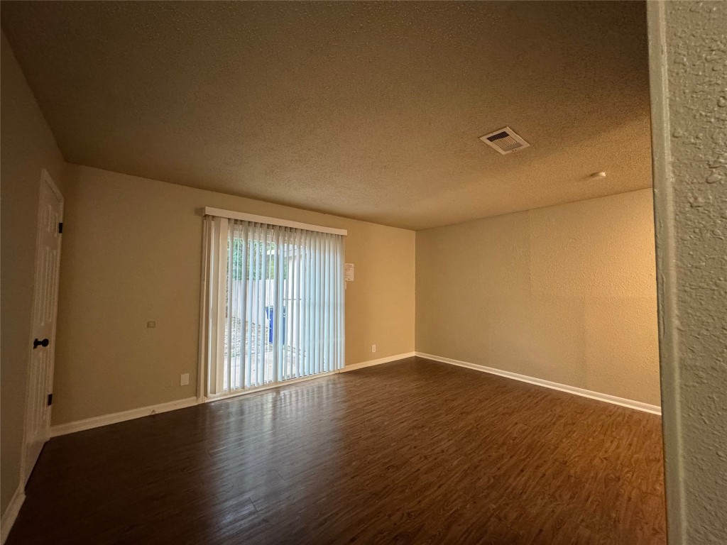 5006 West Wind Trail, Unit 104 Austin, TX 78745 - Photo 3 of 20 a view of an empty room with wooden floor and a window