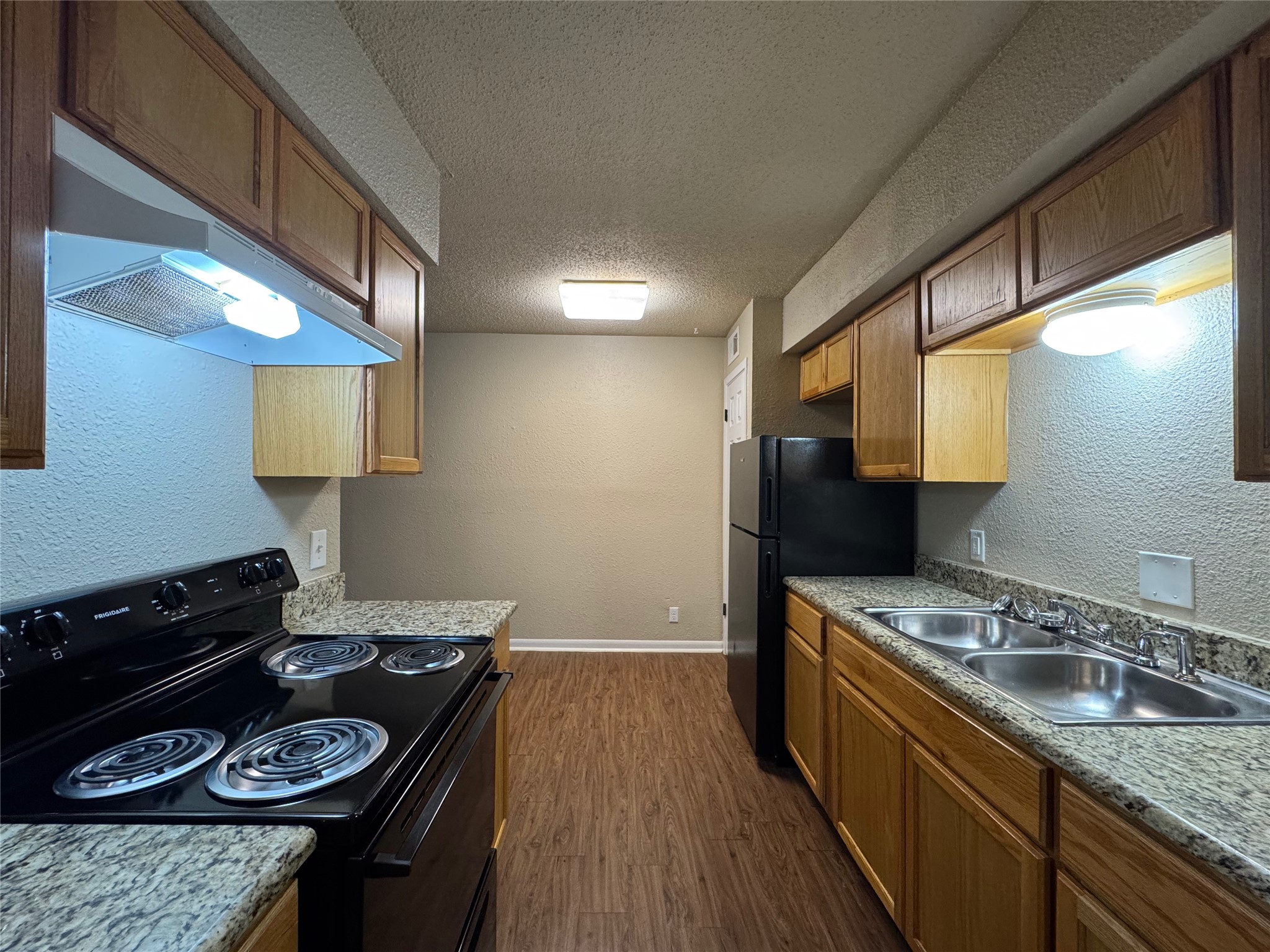 5006 West Wind Trail, Unit 104 Austin, TX 78745 - Photo 6 of 20 a kitchen with a stove a sink and a refrigerator