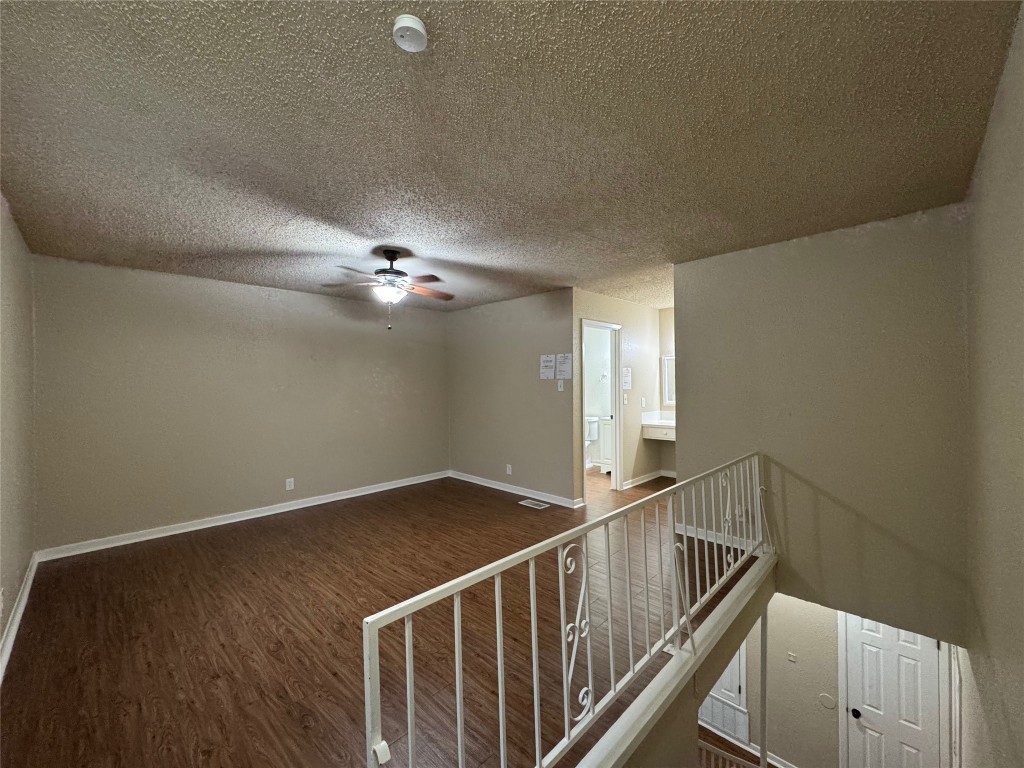 5006 West Wind Trail, Unit 104 Austin, TX 78745 - Photo 10 of 20 a view of an empty room with stairs and wooden floor