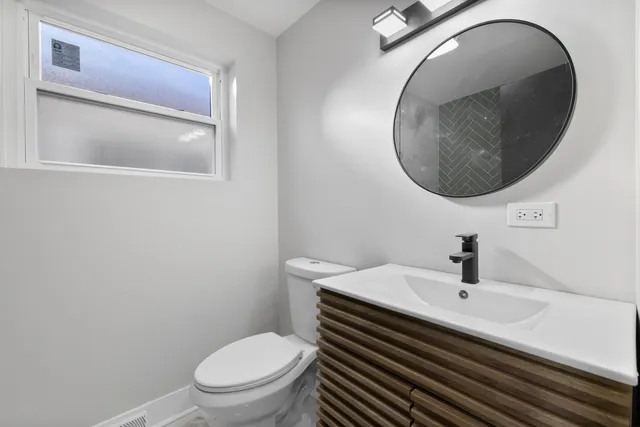 a bathroom with a sink a toilet and a mirror