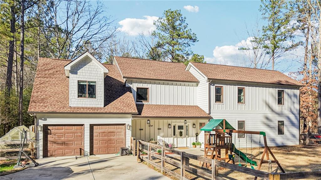 744 Narroway Trail Dallas, GA 30132 - Photo 1 of 59 a view of a white house with a table and chairs under an umbrella