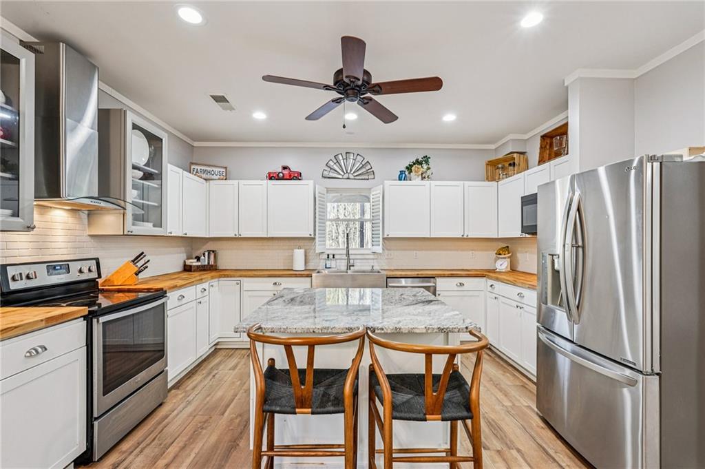 744 Narroway Trail Dallas, GA 30132 - Photo 19 of 59 a kitchen with stainless steel appliances granite countertop a dining table chairs refrigerator and cabinets