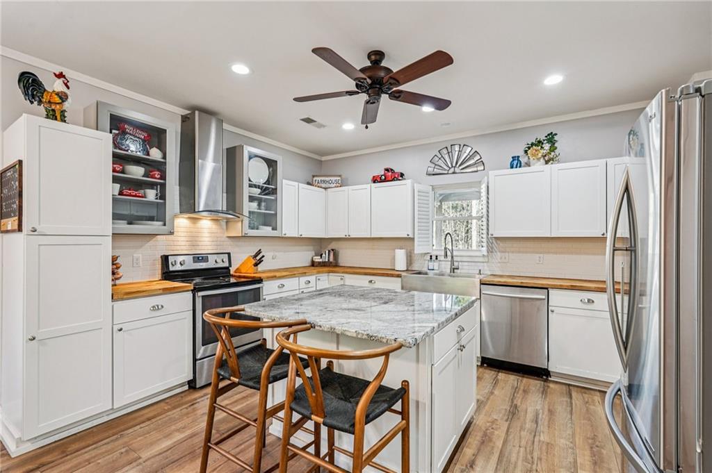 744 Narroway Trail Dallas, GA 30132 - Photo 21 of 59 a kitchen with stainless steel appliances granite countertop a refrigerator a sink dishwasher and white cabinets with wooden floor