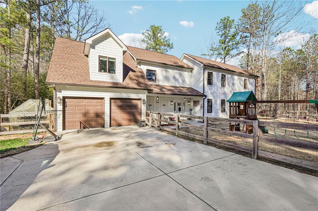744 Narroway Trail Dallas, GA 30132 - Photo 3 of 59 a view of a white house with large windows and a table and chairs under an umbrella