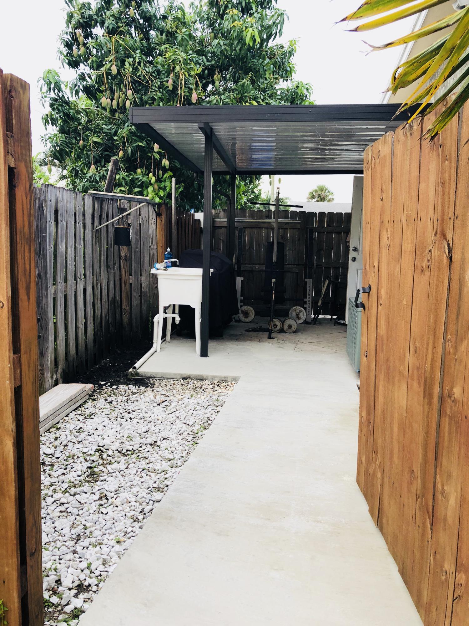 4228 Gulfstream Road Lake Worth, FL 33461 - Photo 21 of 21 a backyard of a house with a table and chairs
