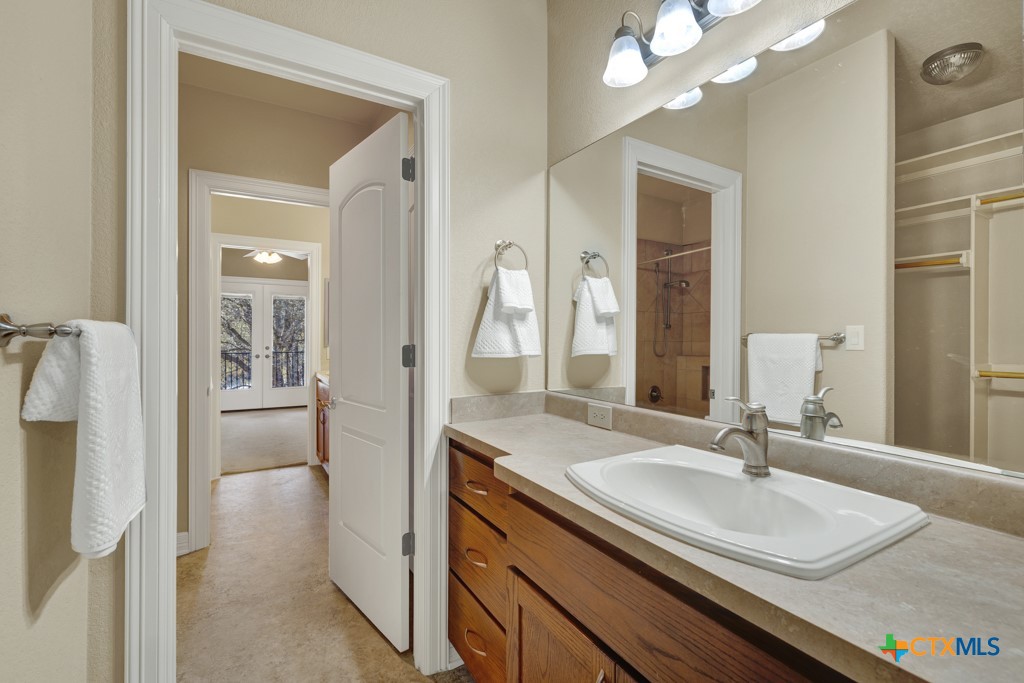 7607 Sky Loop Garden Ridge, TX 78266 - Photo 32 of 43 a en suite bathroom with a sink and a mirror