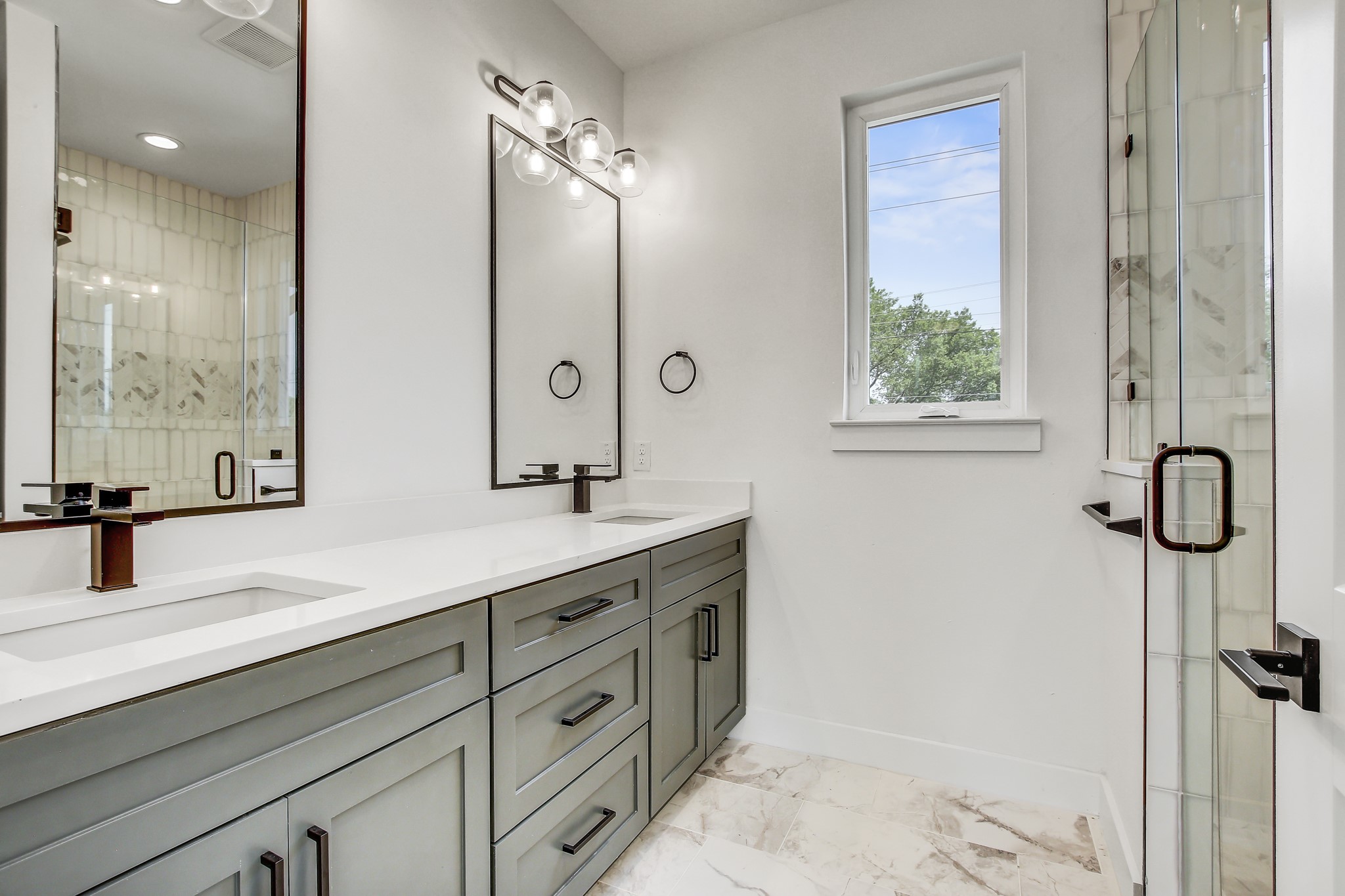 4127 East 12th Street, Unit 3 Austin, TX 78721 - Photo 4 of 29 Full bath with marble look tiles, baseboards, double vanity, and a shower stall