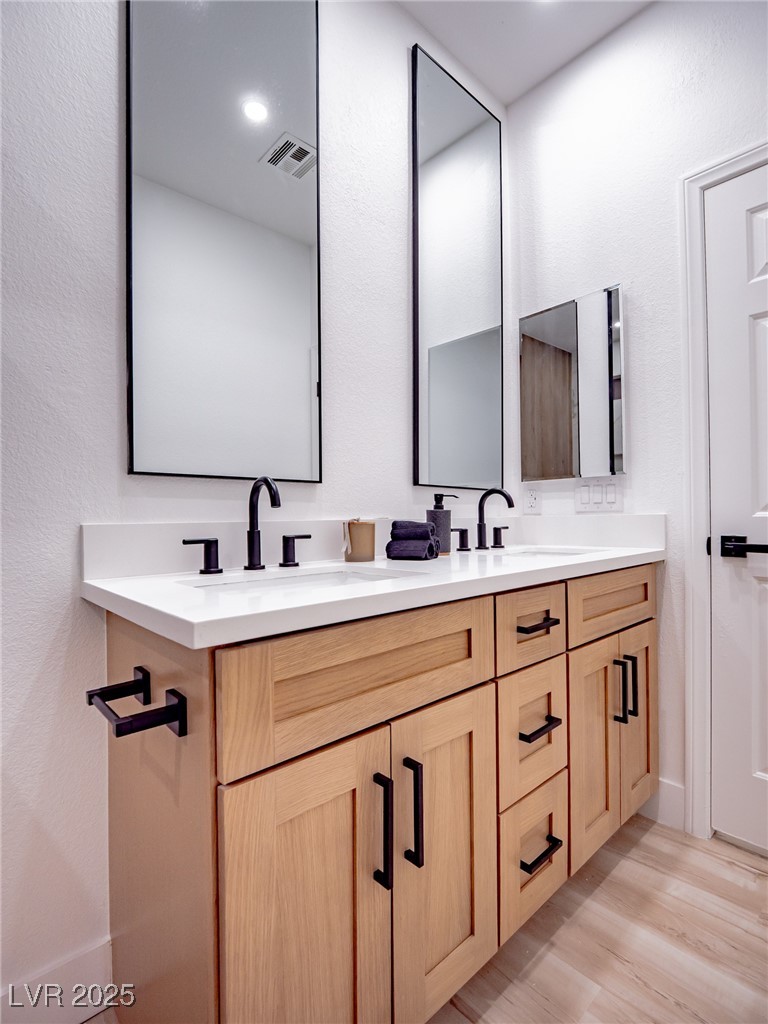 7870 Midnight Ride Street Las Vegas, NV 89131 - Photo 32 of 69 Full bath with double vanity, light wood-style floors, and a textured wall