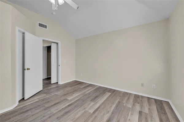 a view of an empty room with wooden floor