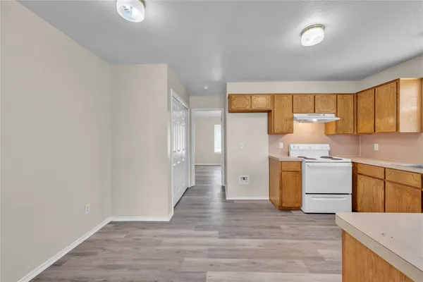 a kitchen with a refrigerator stove and wooden cabinets