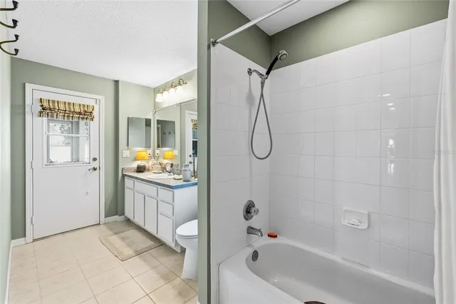 a bathroom with a granite countertop sink a mirror and a bathtub
