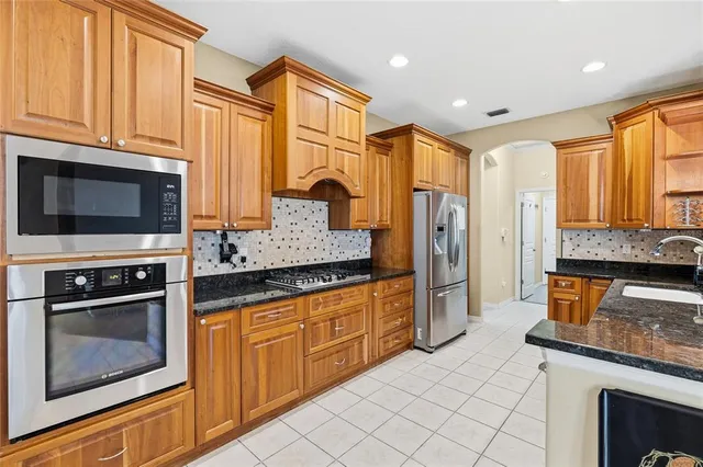 a kitchen with stainless steel appliances granite countertop a stove a sink and a microwave