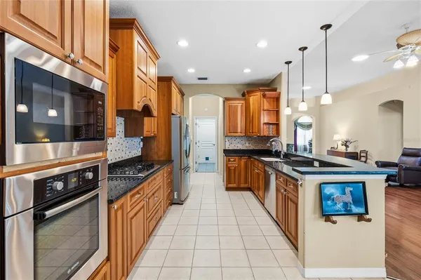 a large kitchen with stainless steel appliances granite countertop a stove a sink and a refrigerator