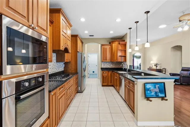 a large kitchen with stainless steel appliances granite countertop a stove a sink and a refrigerator