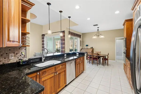a kitchen with granite countertop a sink a counter top space appliances and cabinets