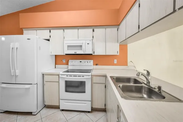 a view of a kitchen with a refrigerator and a sink