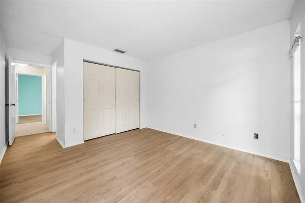 a view of an empty room with closet and a window