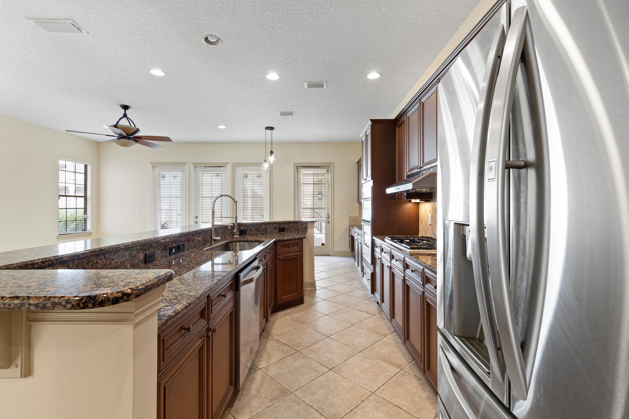 650 South Loop Street St. Augustine, FL 32095 - Photo 5 of 40 a kitchen with granite countertop a refrigerator a stove and a sink