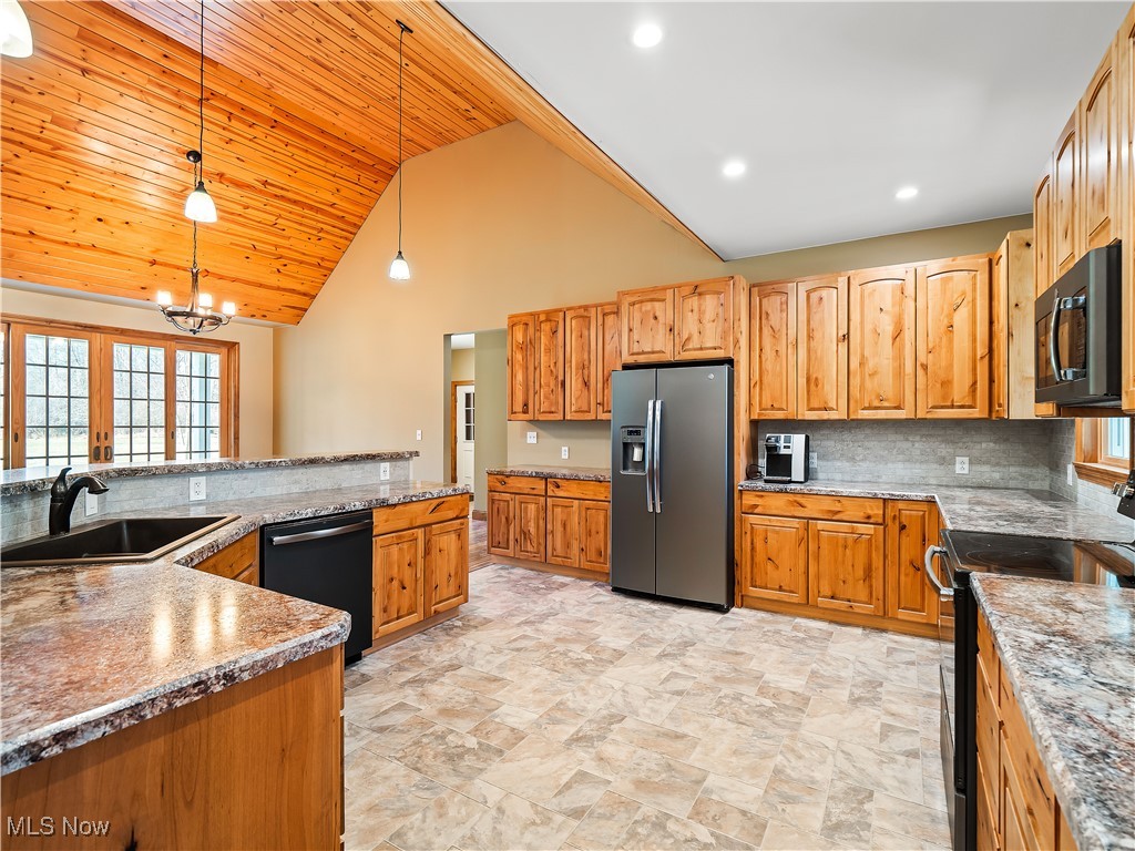 12740 Root Road Columbia Station, OH 44028 - Photo 22 of 47 Kitchen featuring tasteful backsplash, hanging light fixtures, a notable chandelier, black appliances, and a sink
