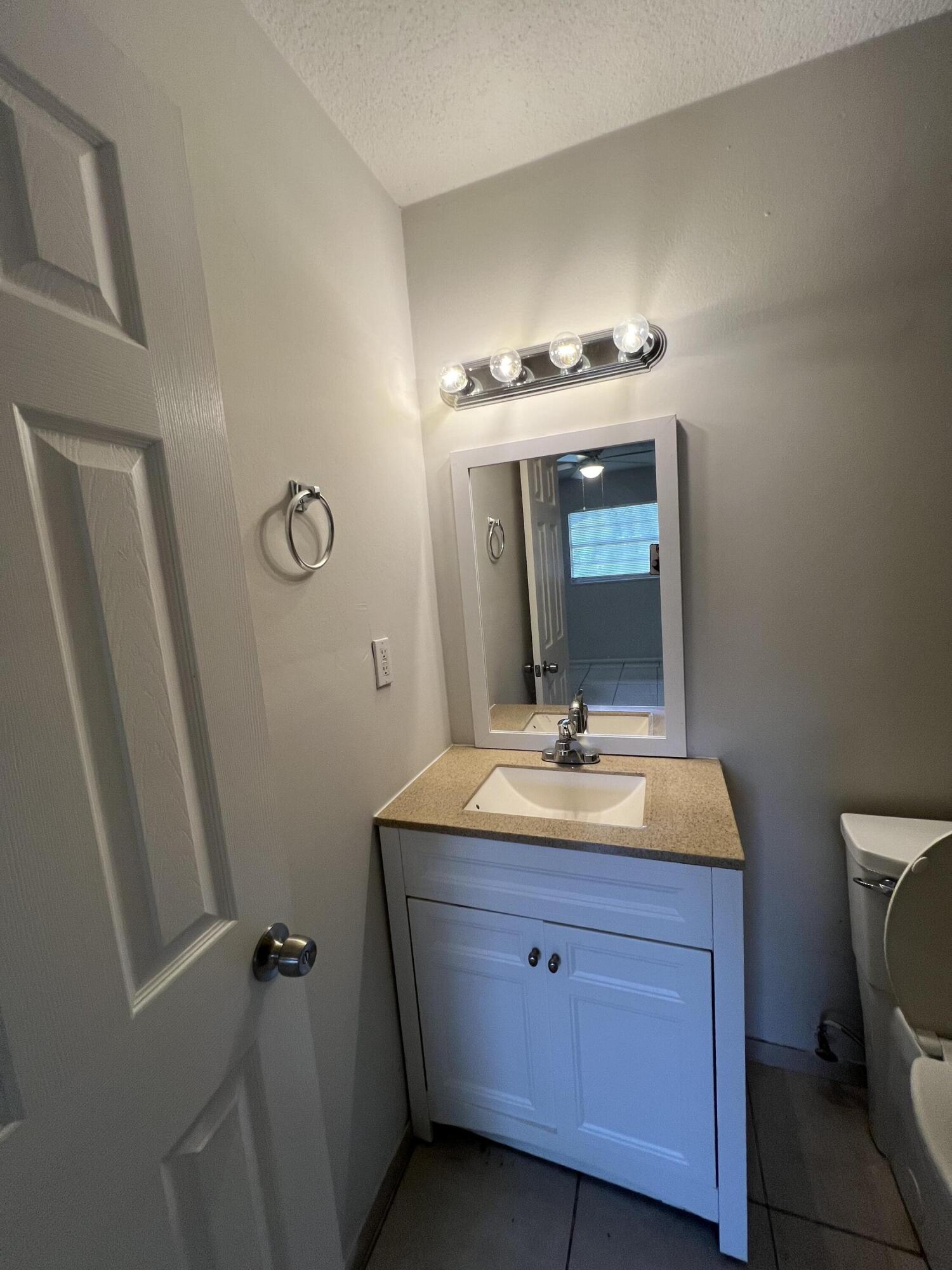 6703 Pensacola Road Fort Pierce, FL 34951 - Photo 12 of 15 a bathroom with a double vanity sink and mirror