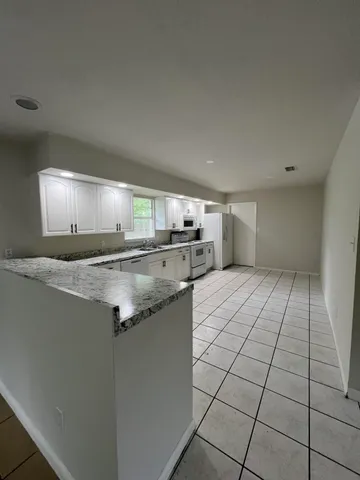 a kitchen with granite countertop a sink and cabinets