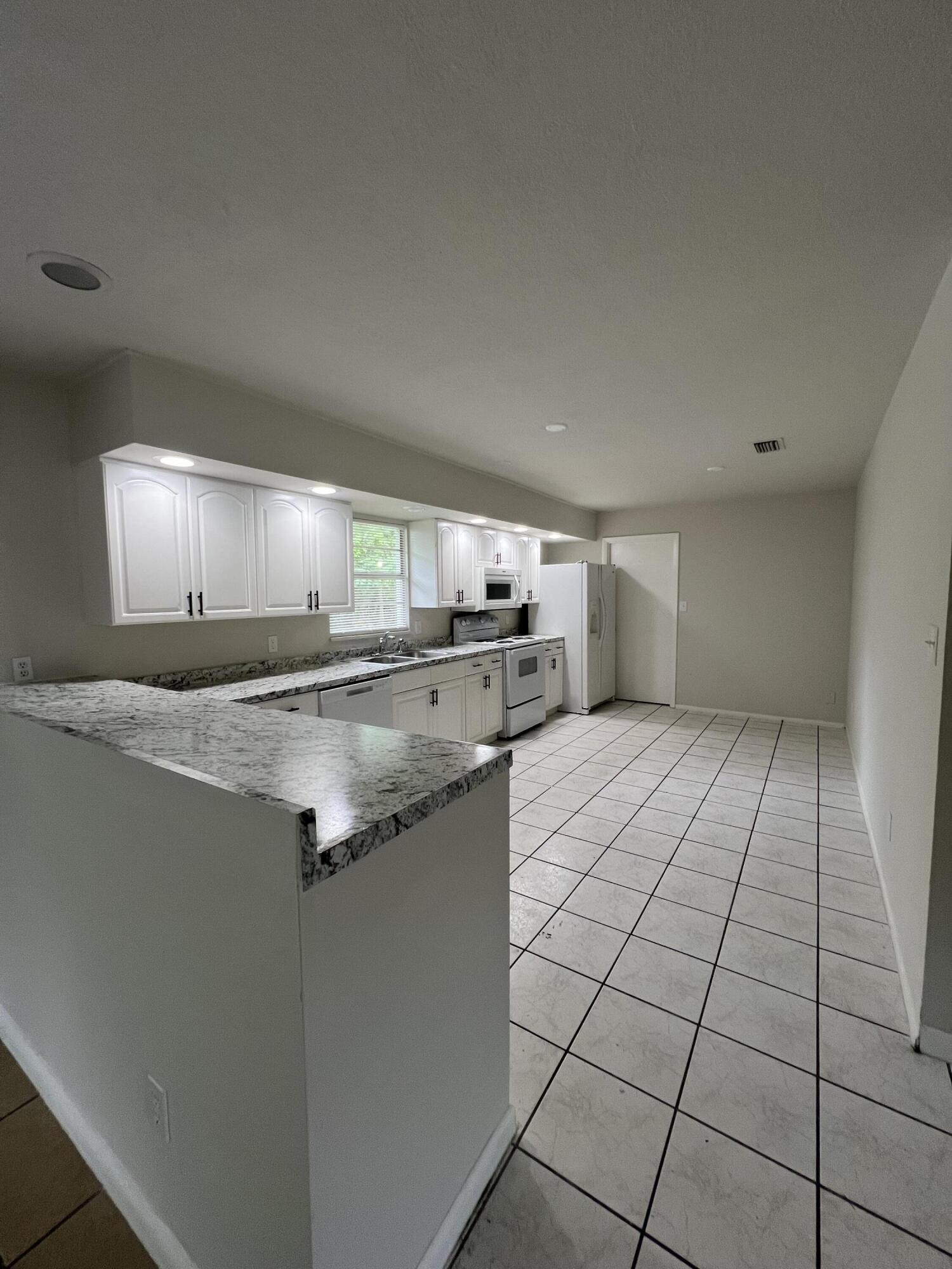 6703 Pensacola Road Fort Pierce, FL 34951 - Photo 6 of 15 a kitchen with granite countertop a sink and cabinets