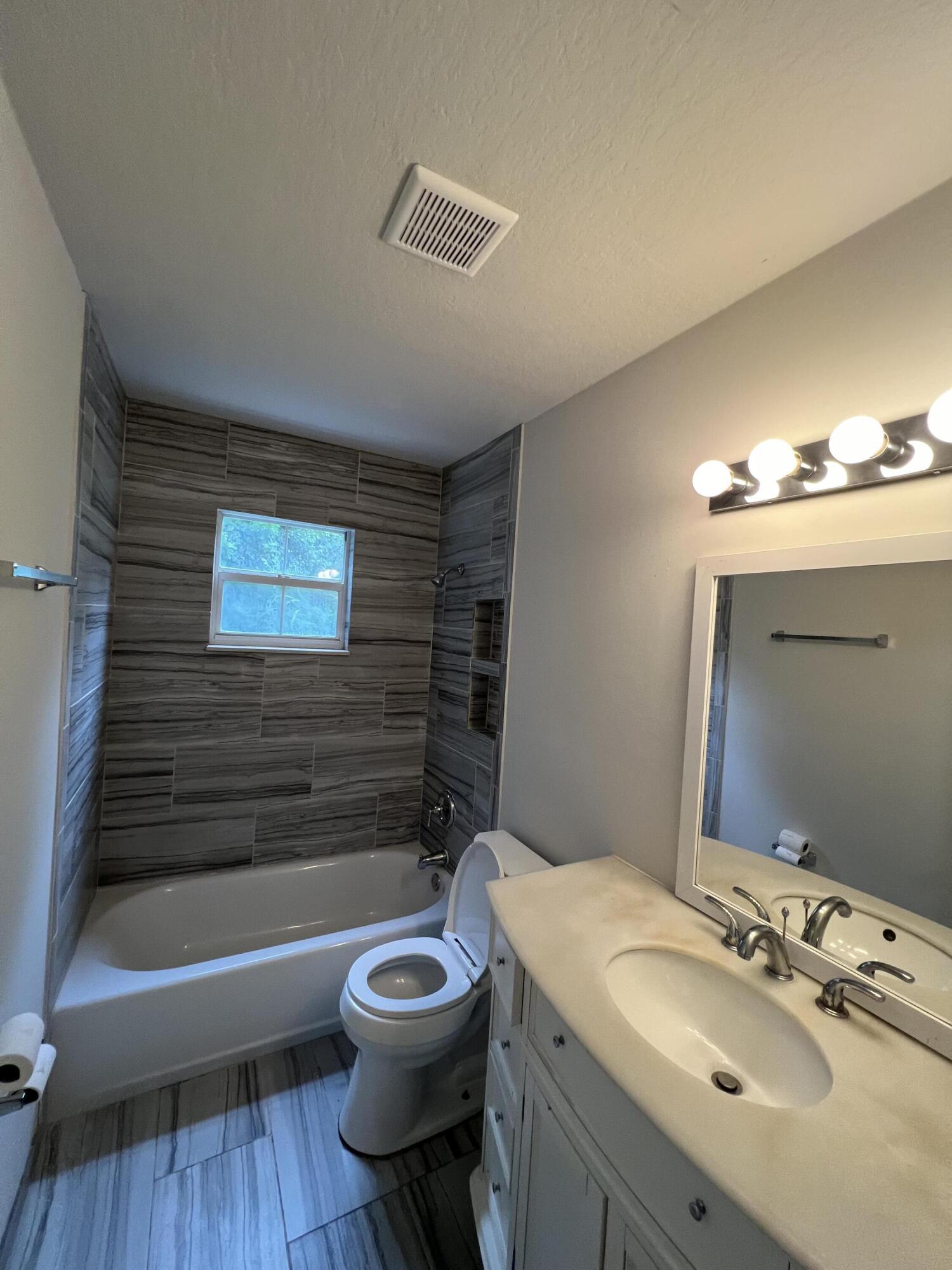 6703 Pensacola Road Fort Pierce, FL 34951 - Photo 10 of 15 a bathroom with a sink toilet a mirror and bathtub