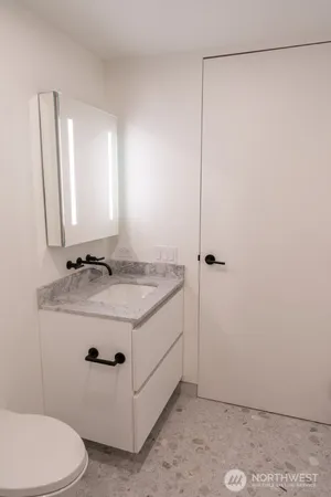 a bathroom with a granite countertop sink toilet and shower