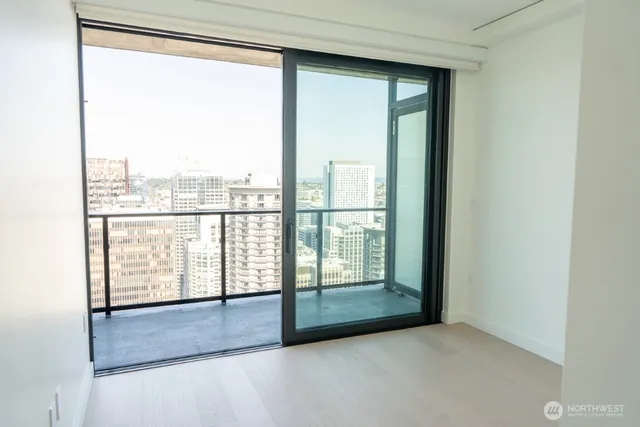 a view of an empty room with wooden floor and doors
