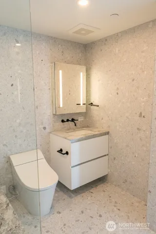 a bathroom with a sink a toilet and shower
