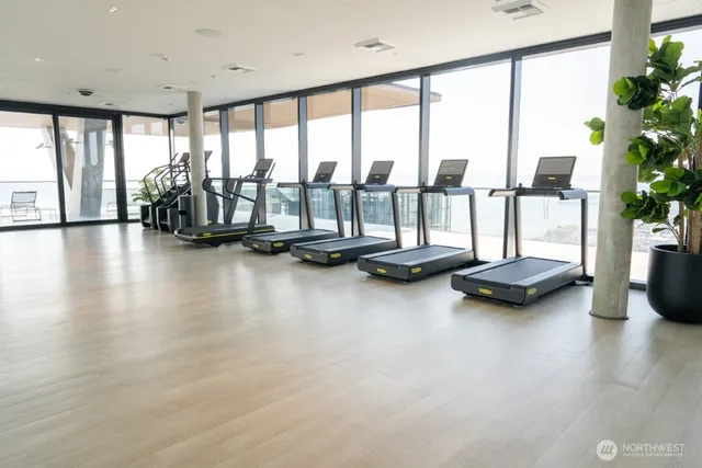 a view of room with gym equipment and large windows