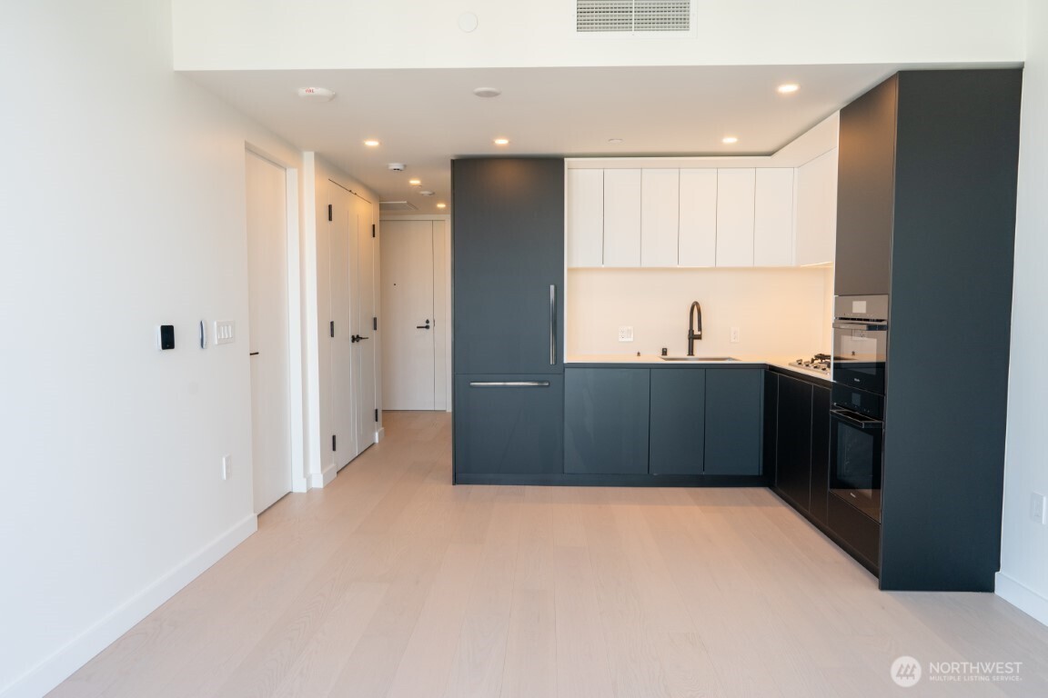 300 Virginia Street, Unit 4403 Seattle, WA 98101 - Photo 8 of 40 a kitchen with stainless steel appliances a refrigerator and a sink