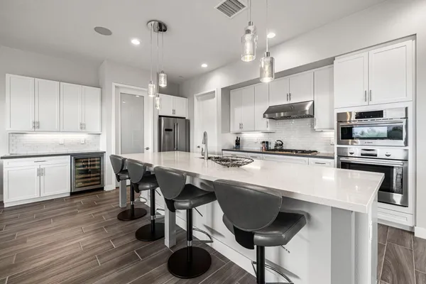 a large kitchen with kitchen island a dining table chairs and a sink