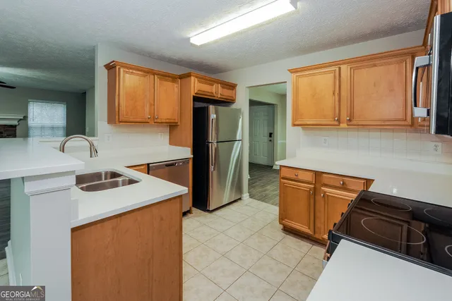 a kitchen with stainless steel appliances granite countertop a sink refrigerator and microwave