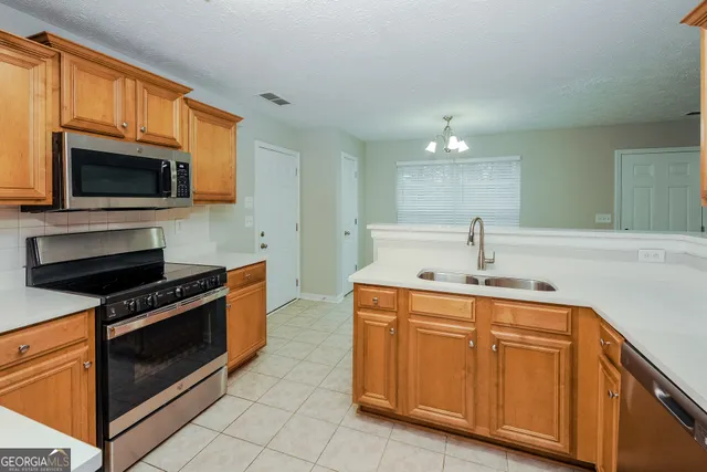 a kitchen with stainless steel appliances a stove microwave and sink