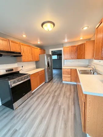 a kitchen with stainless steel appliances a stove and a sink