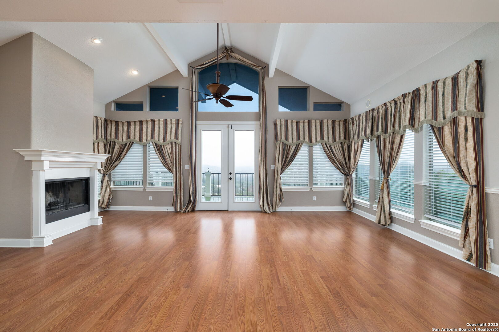 11235 Indian Caves Helotes, TX 78023 - Photo 8 of 45 an empty room with wooden floor fireplace and windows