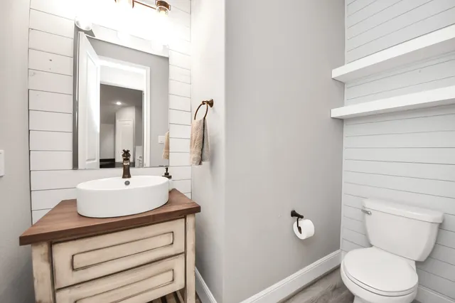 a large white kitchen with a stove a sink dishwasher and a refrigerator with wooden floor