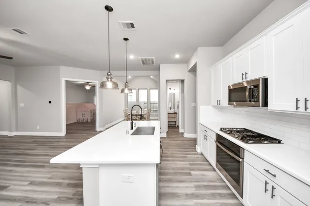 a view of kitchen with sink and refrigerator