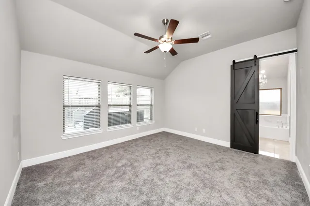 an empty room with closet and a ceiling fan