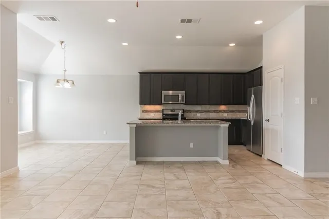 a kitchen with stainless steel appliances granite countertop a stove a sink and a refrigerator