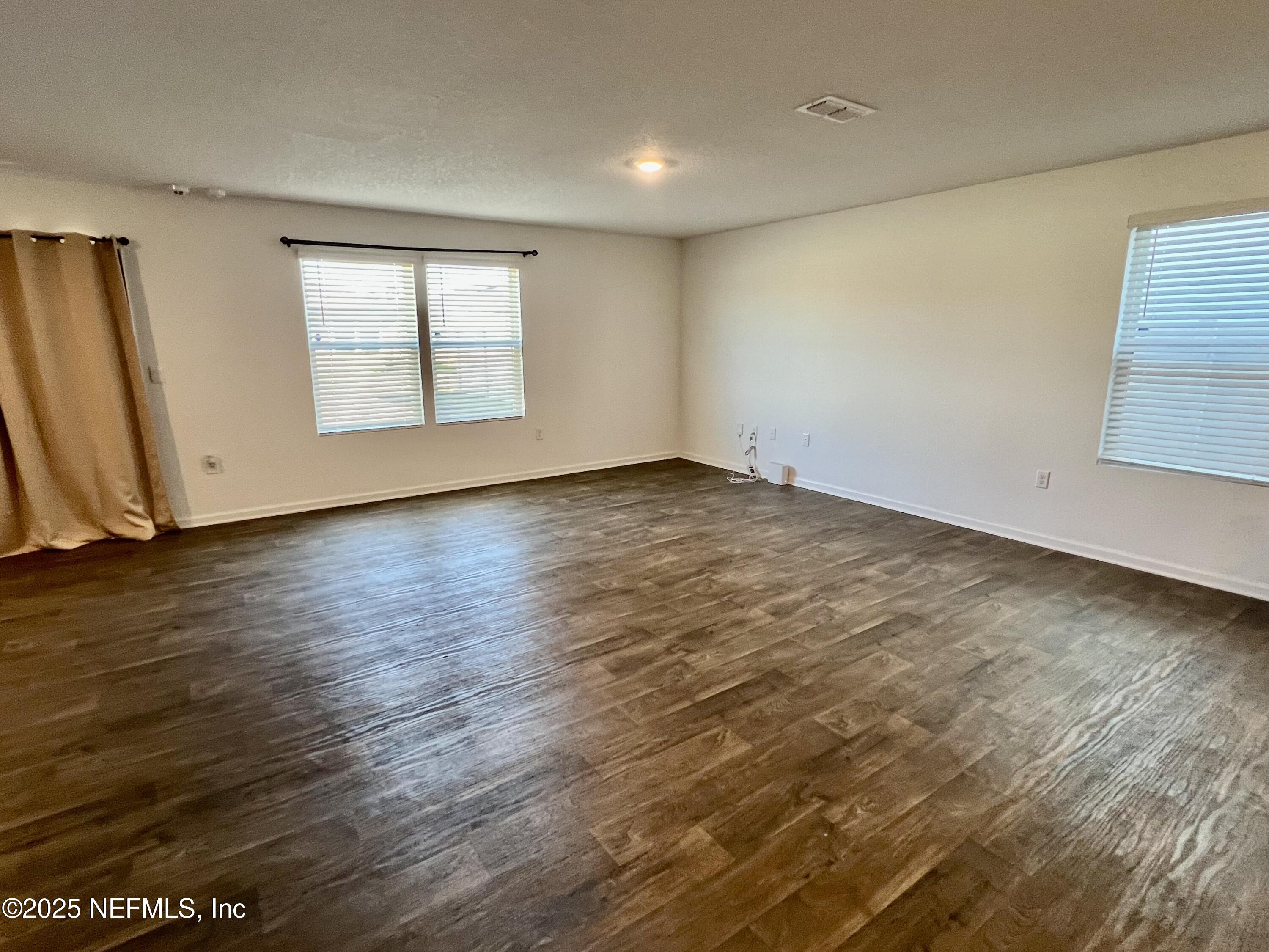 12659 European Beech Road Jacksonville, FL 32218 - Photo 11 of 30 an empty room with wooden floor and windows