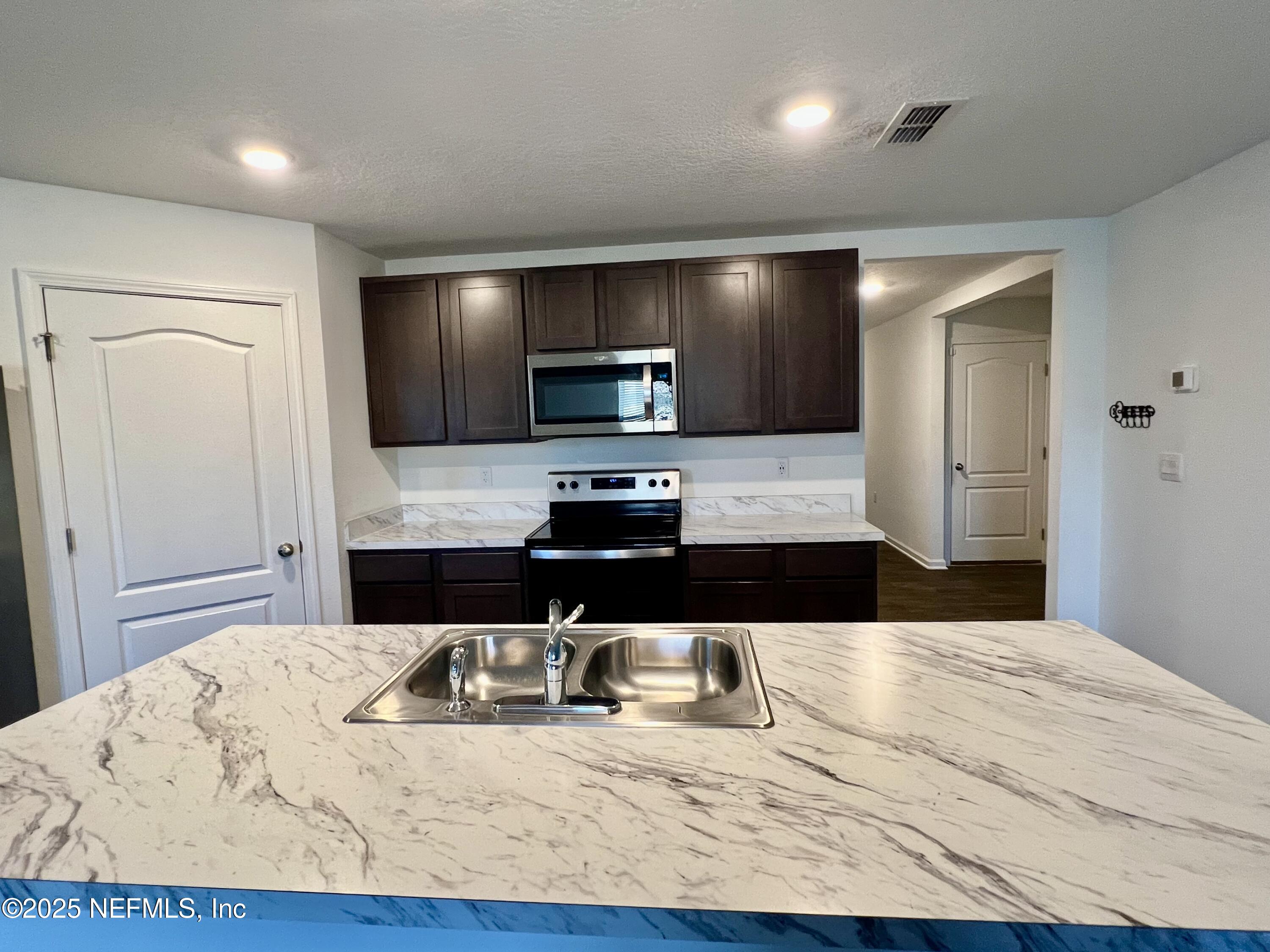 12659 European Beech Road Jacksonville, FL 32218 - Photo 8 of 30 a kitchen with granite countertop a refrigerator and a sink