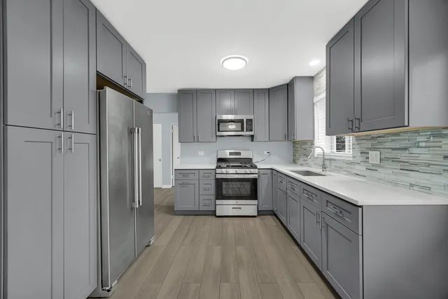 a kitchen with stainless steel appliances granite countertop a refrigerator stove and sink