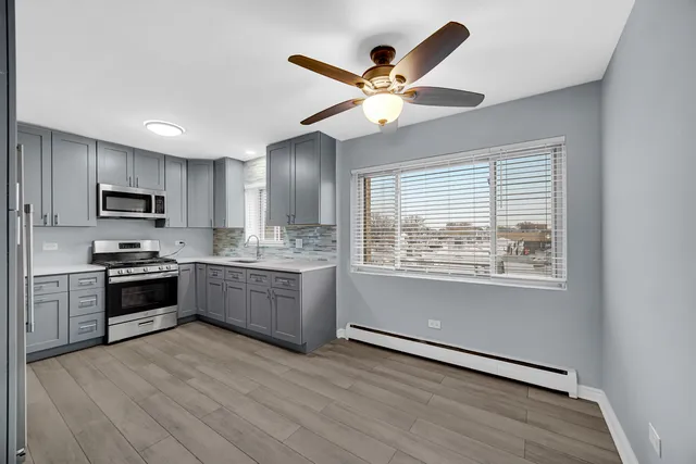a kitchen with granite countertop stainless steel appliances a stove cabinets and a refrigerator